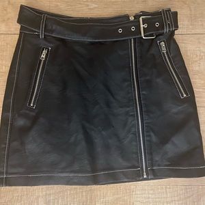 Fake leather skirt . 2 zipper pockets . Belt and zips
down in the front.